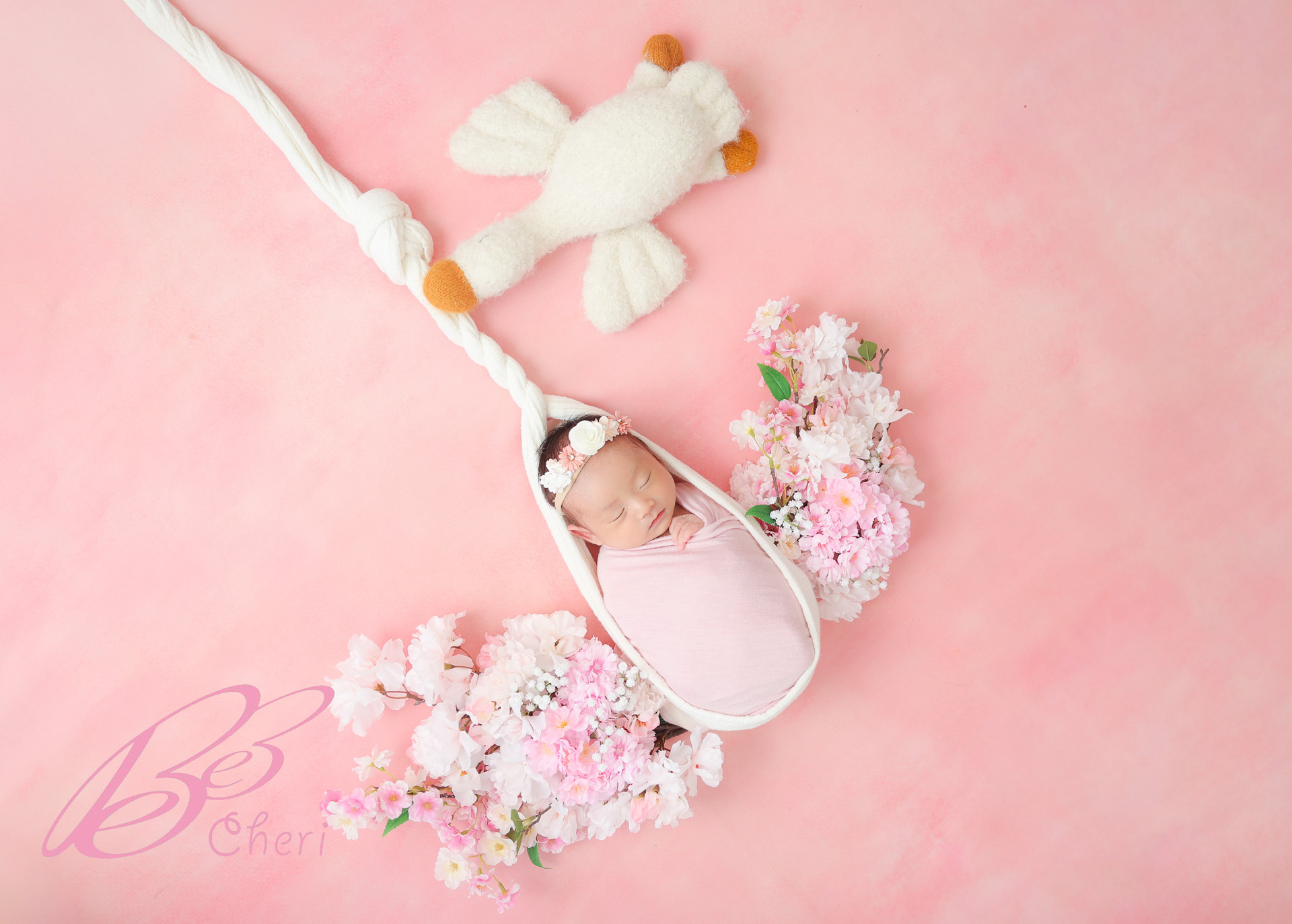 東京都港区南麻布でニューボーンフォト コウノトリが運ぶ赤ちゃんに桜が添えられたアートポーズ